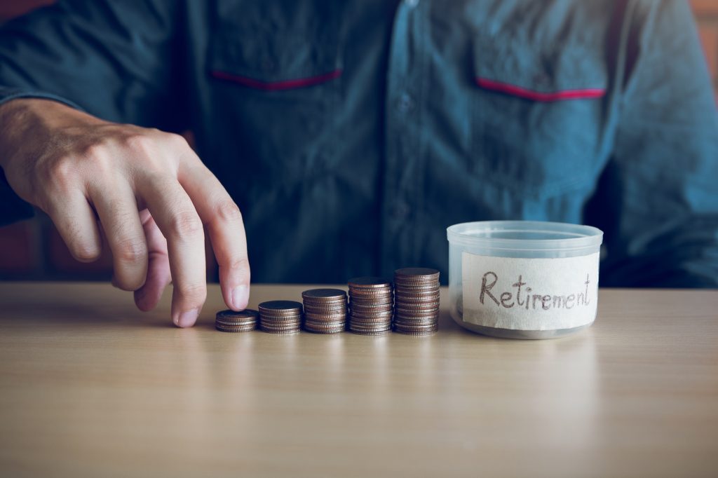 Men are holding coins dropping to the money box with the concept of saving.